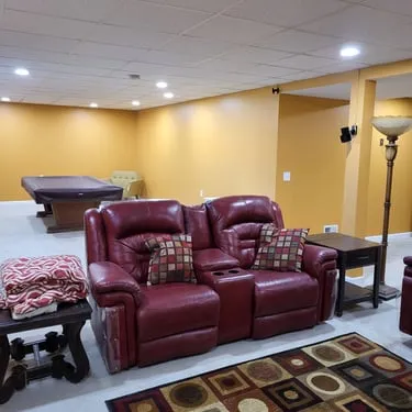 Finished basement lounge with red leather chairs, a pool table, and recessed lighting