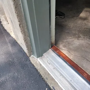 Close view of a threshold and trim at the base of an exterior door