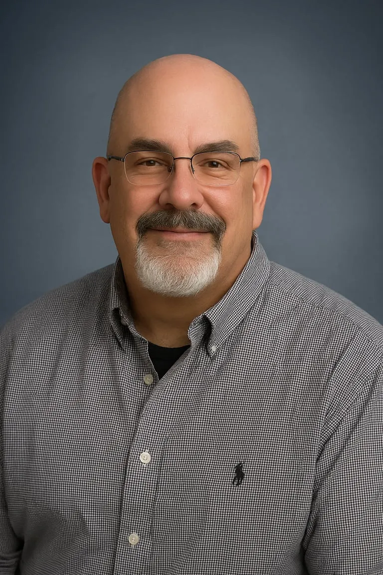Portrait of Kirk Metz wearing glasses and a checked shirt