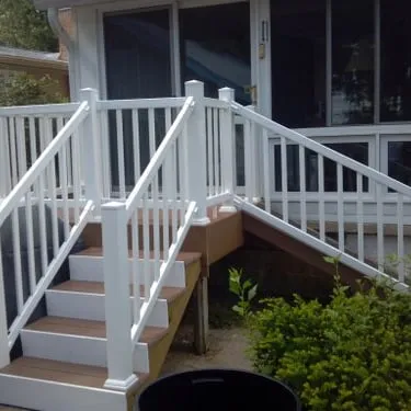 White-painted deck stairs and railings leading to a home entrance